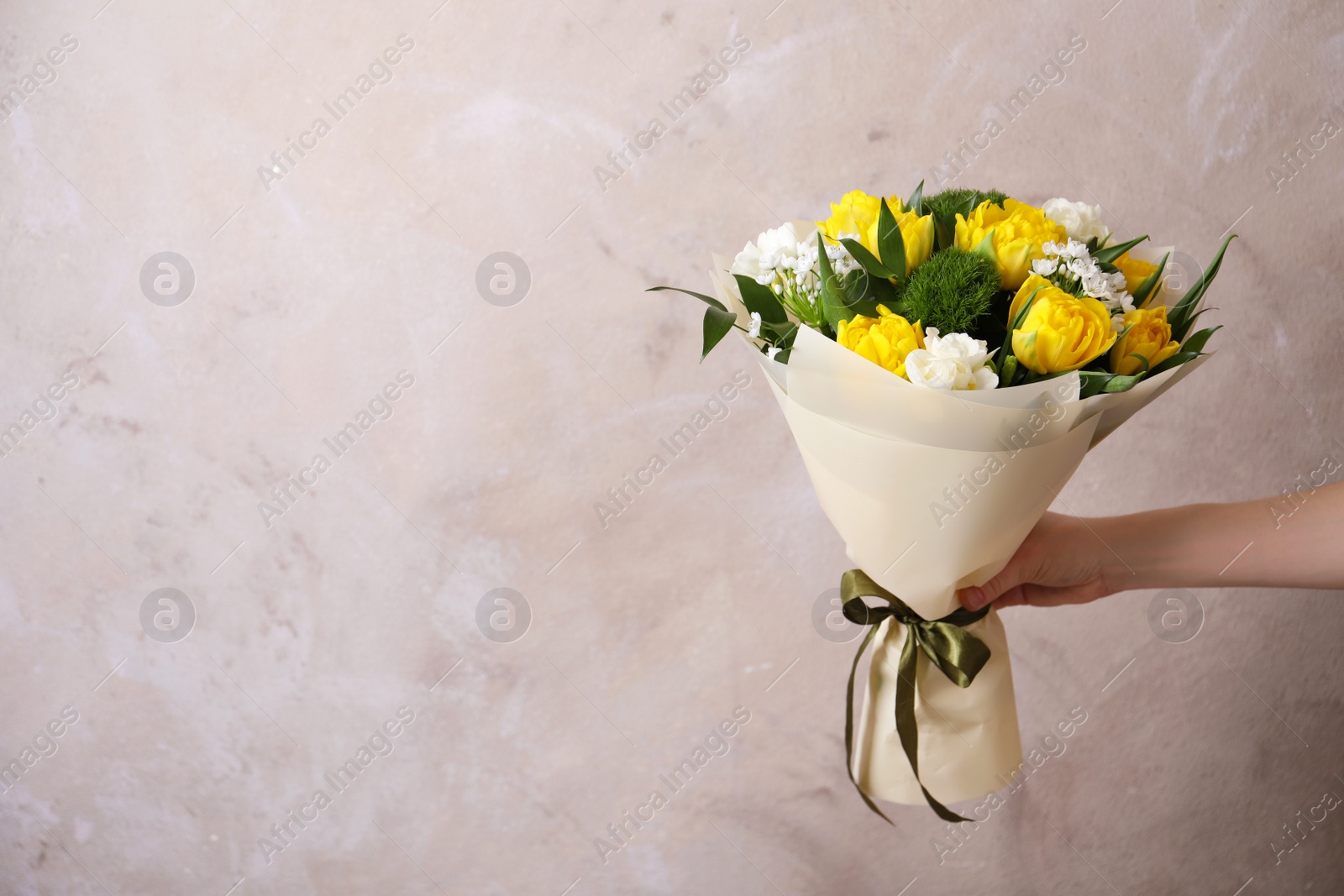 Photo of Woman with bouquet of beautiful tulips on beige background. Space for text