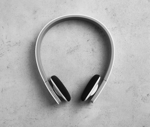 Photo of Stylish modern headphones on gray background, top view