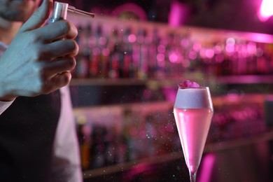 Photo of Bartender making fresh alcoholic cocktail on blurred background, closeup