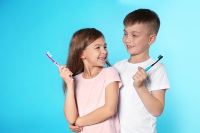 Cute children with toothbrushes on color background