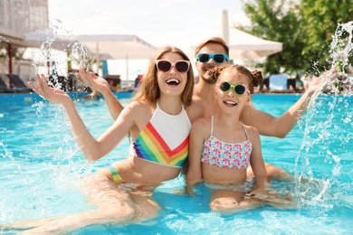 Happy family in pool on sunny day