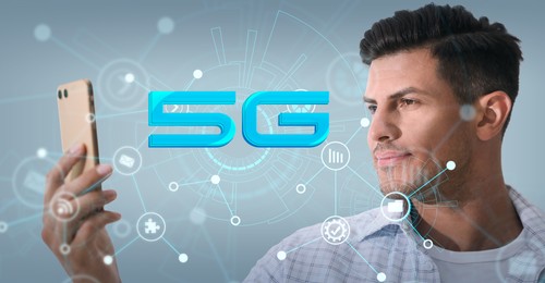 Image of Man using smartphone with 5G network system against light blue background. Banner design