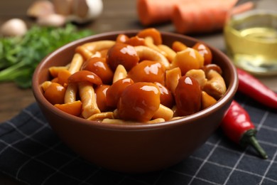 Photo of Tasty marinated mushrooms in bowl on table, closeup