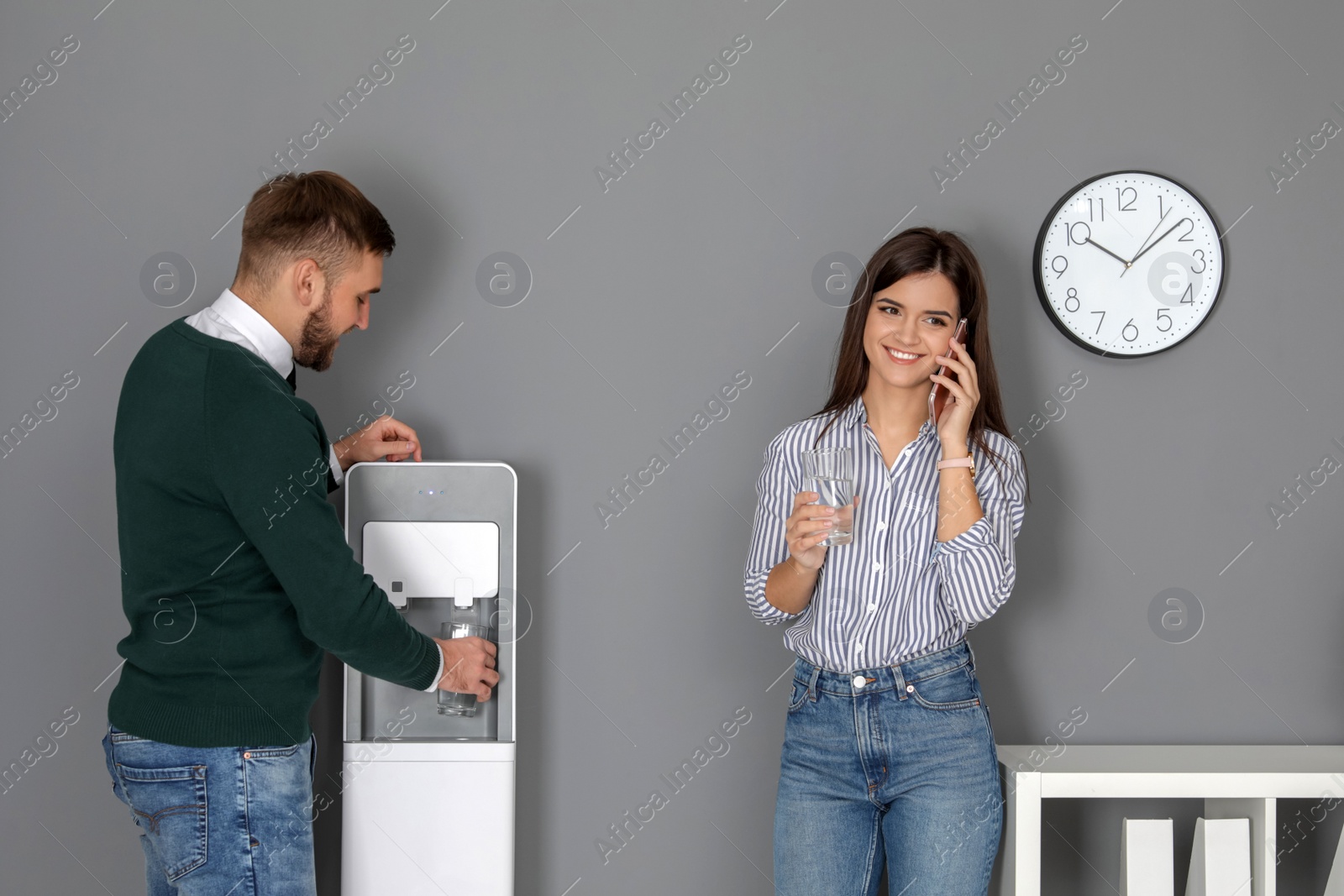 Photo of Employees having break near water cooler in office