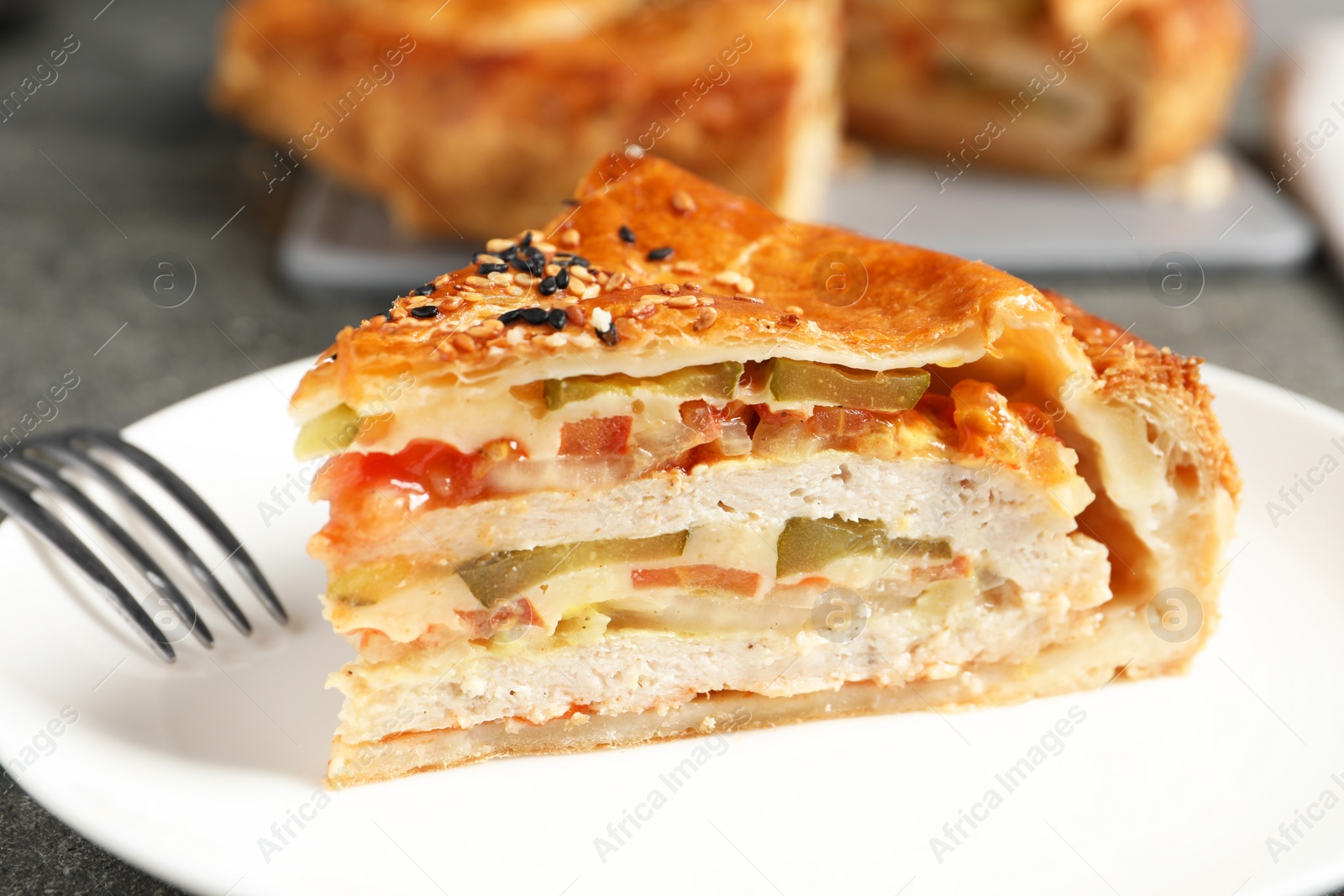 Photo of Piece of tasty homemade pie with filling served on grey table, closeup