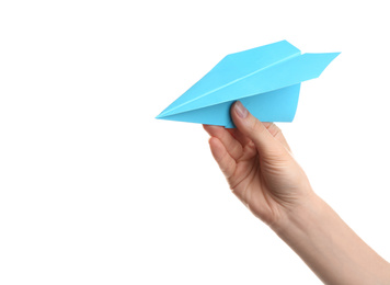 Photo of Woman holding light blue paper plane on white background, closeup