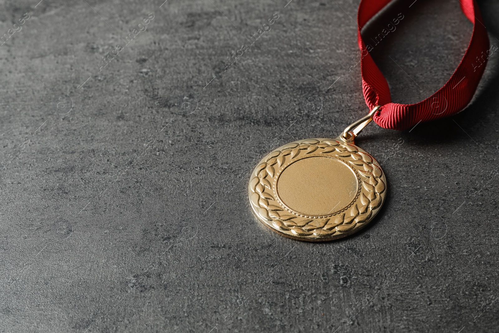 Photo of Gold medal with space for design on grey background. Victory concept