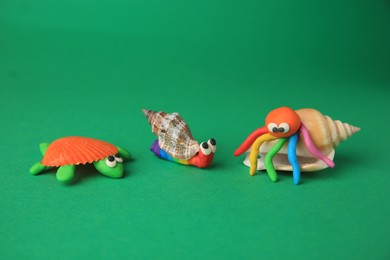 Turtle, crab and snail made from plasticine on green background. Children's handmade ideas