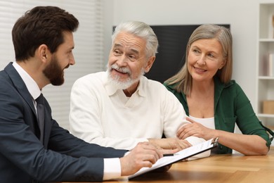 Notary consulting senior couple about Last Will and Testament in office