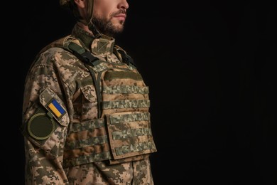 Photo of Soldier in Ukrainian military uniform on black background, closeup. Space for text