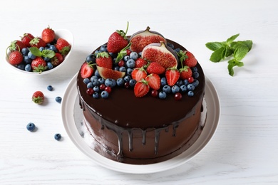 Fresh delicious homemade chocolate cake with berries on light table