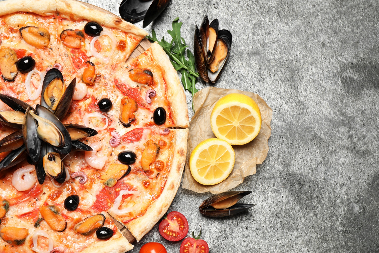 Photo of Tasty pizza with seafood and ingredients on grey table, flat lay