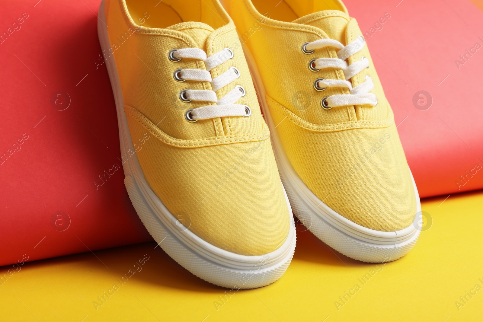 Photo of Comfortable sneakers with laces on color background, closeup