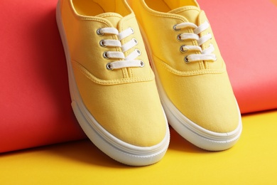 Photo of Comfortable sneakers with laces on color background, closeup