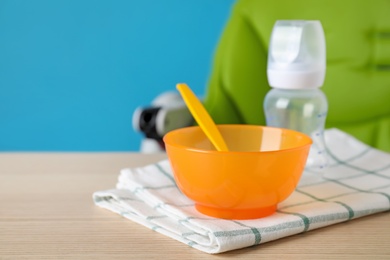 Photo of Set of plastic dishware on wooden table. Serving baby food