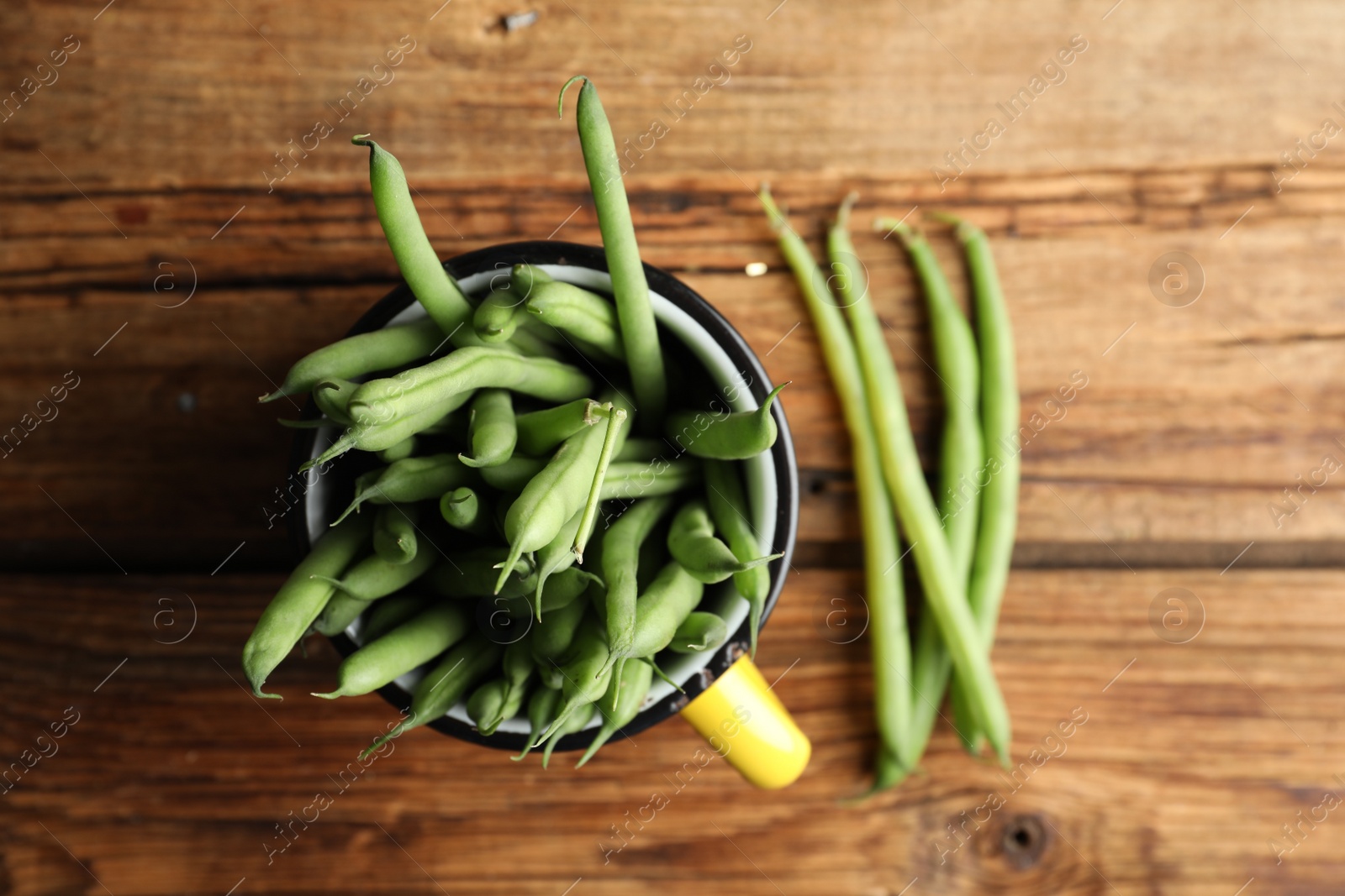 Photo of Fresh green beans on wooden table, flat lay