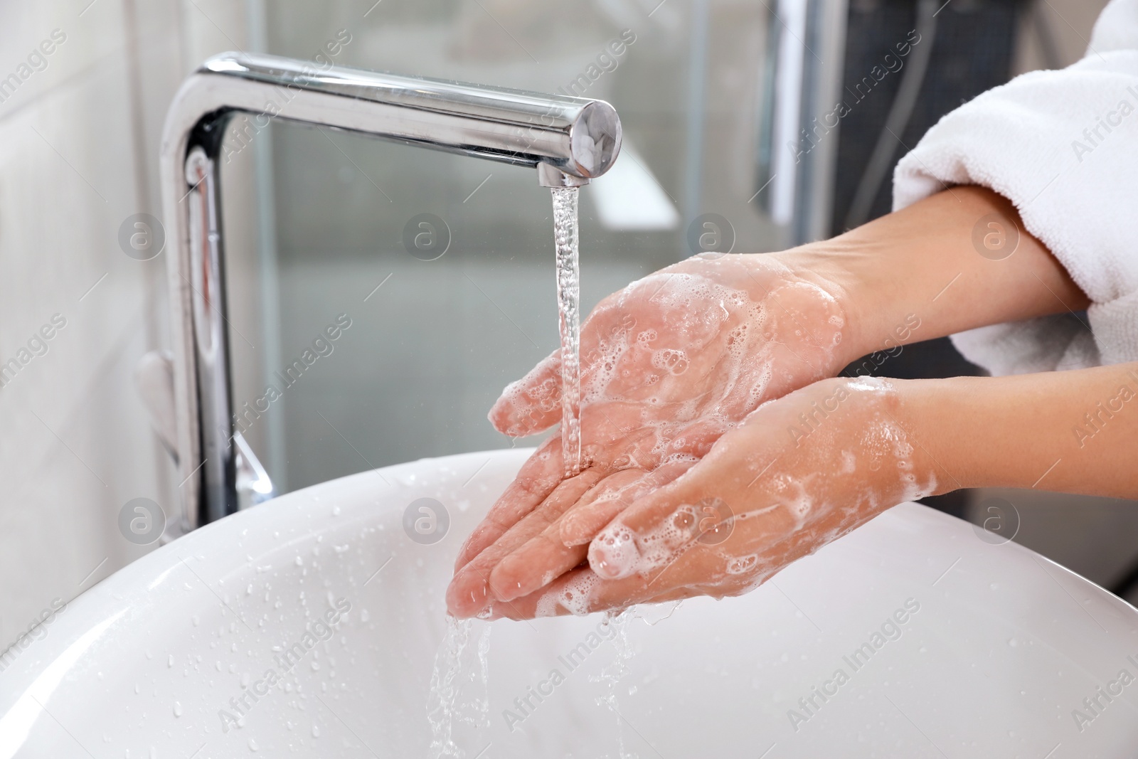 Photo of Woman washing hands with soap over sink in bathroom, closeup