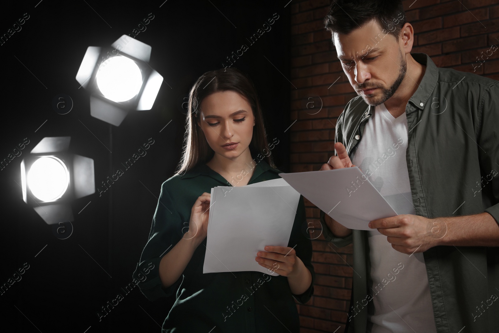 Photo of Professional actors reading their scripts during rehearsal in theatre