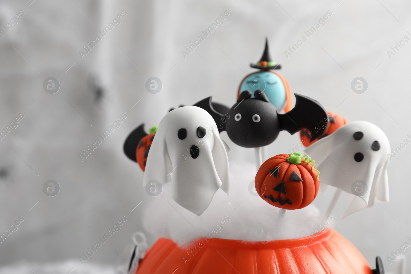 Photo of Different Halloween themed cake pops on light background, closeup