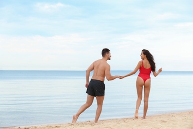 Photo of Happy young couple spending time together on beach near sea