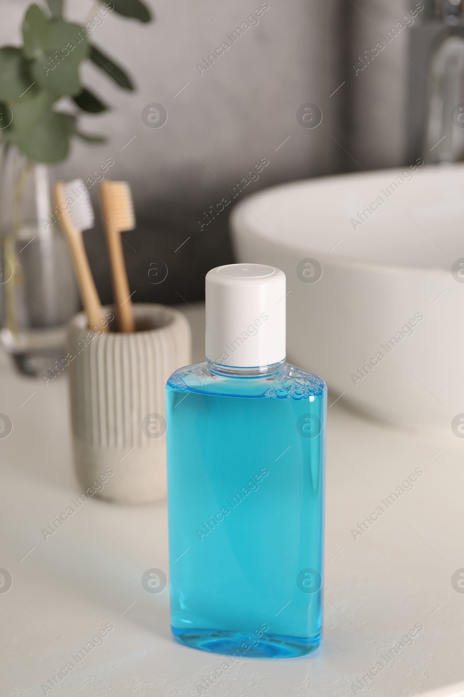 Photo of Bottle of mouthwash on white countertop in bathroom