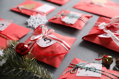 Photo of Set of gifts and Christmas decor on grey stone table, closeup. Advent calendar