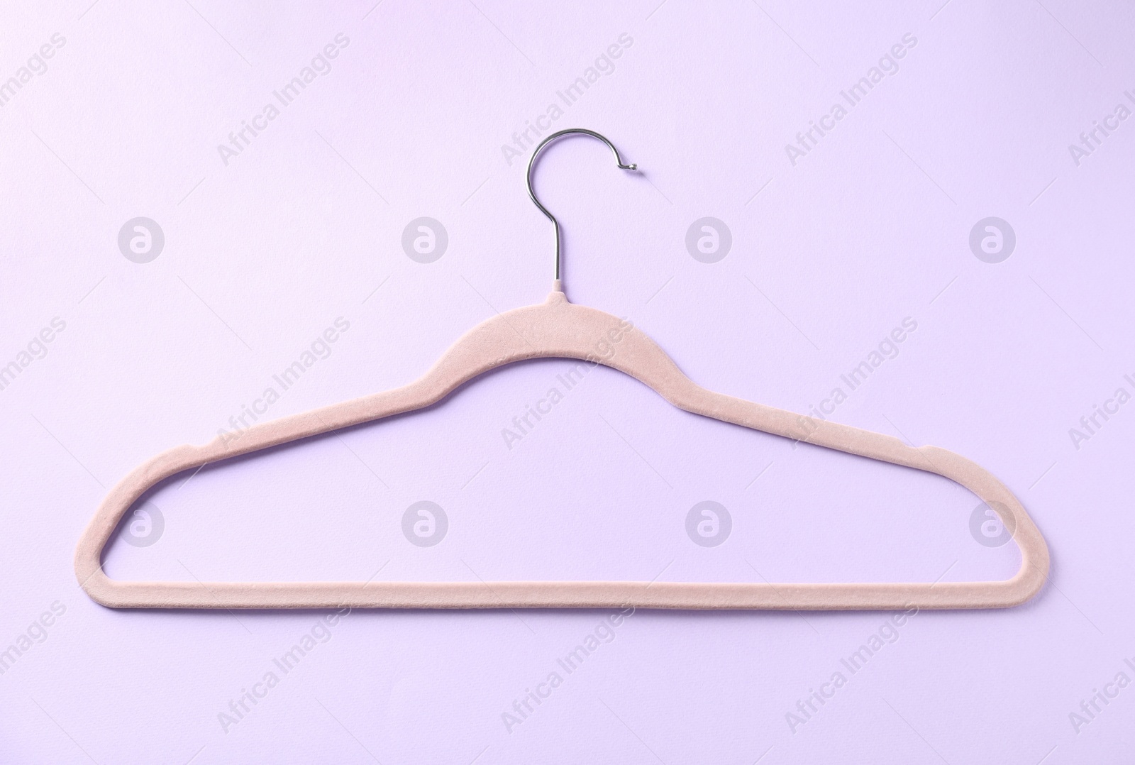 Photo of One beige hanger on violet background, top view
