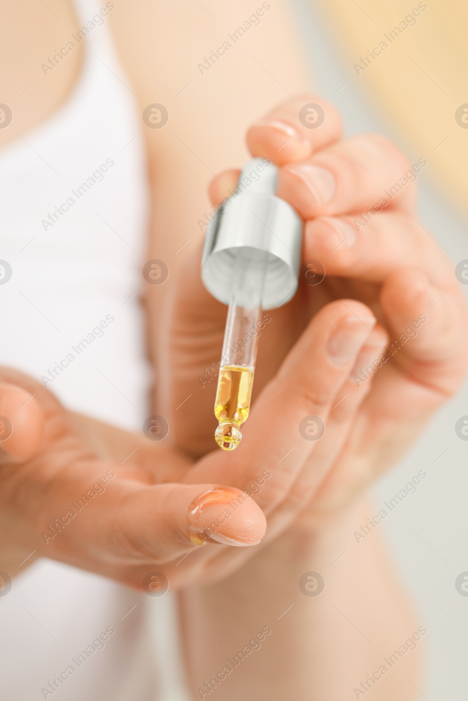 Photo of Woman applying essential oil onto hand, closeup