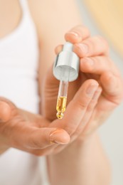 Woman applying essential oil onto hand, closeup