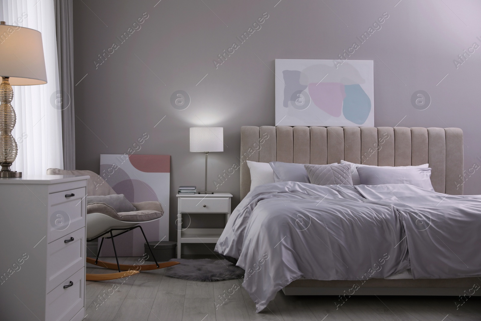 Photo of Cozy bed with soft silky bedclothes in light room