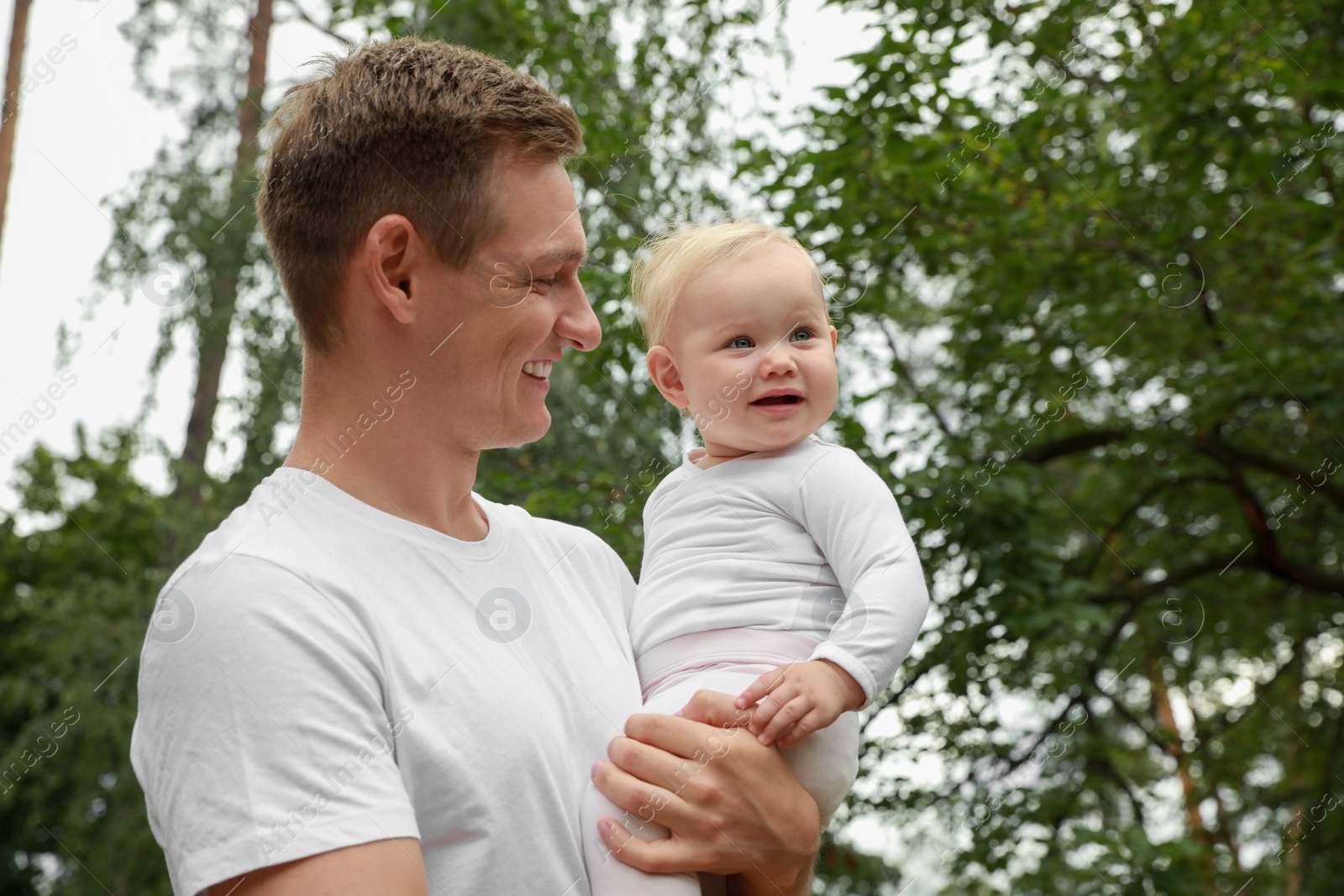 Photo of Father with his cute baby spending time together outdoors