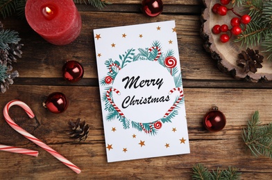 Photo of Flat lay composition with Christmas card and festive decor on wooden background