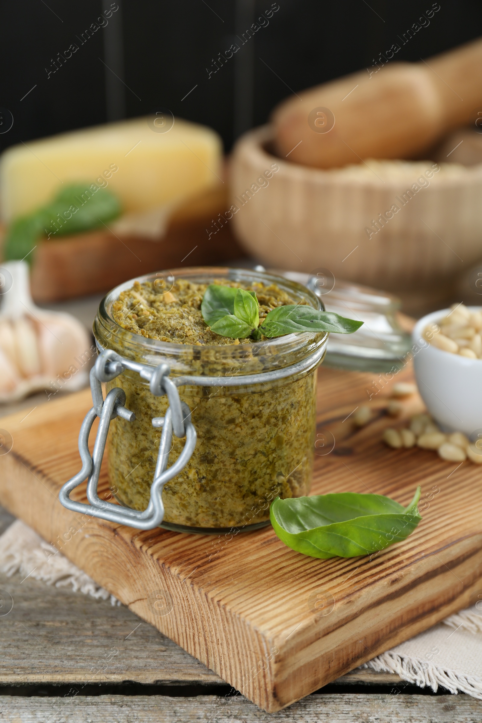 Photo of Delicious pesto sauce in jar on wooden table