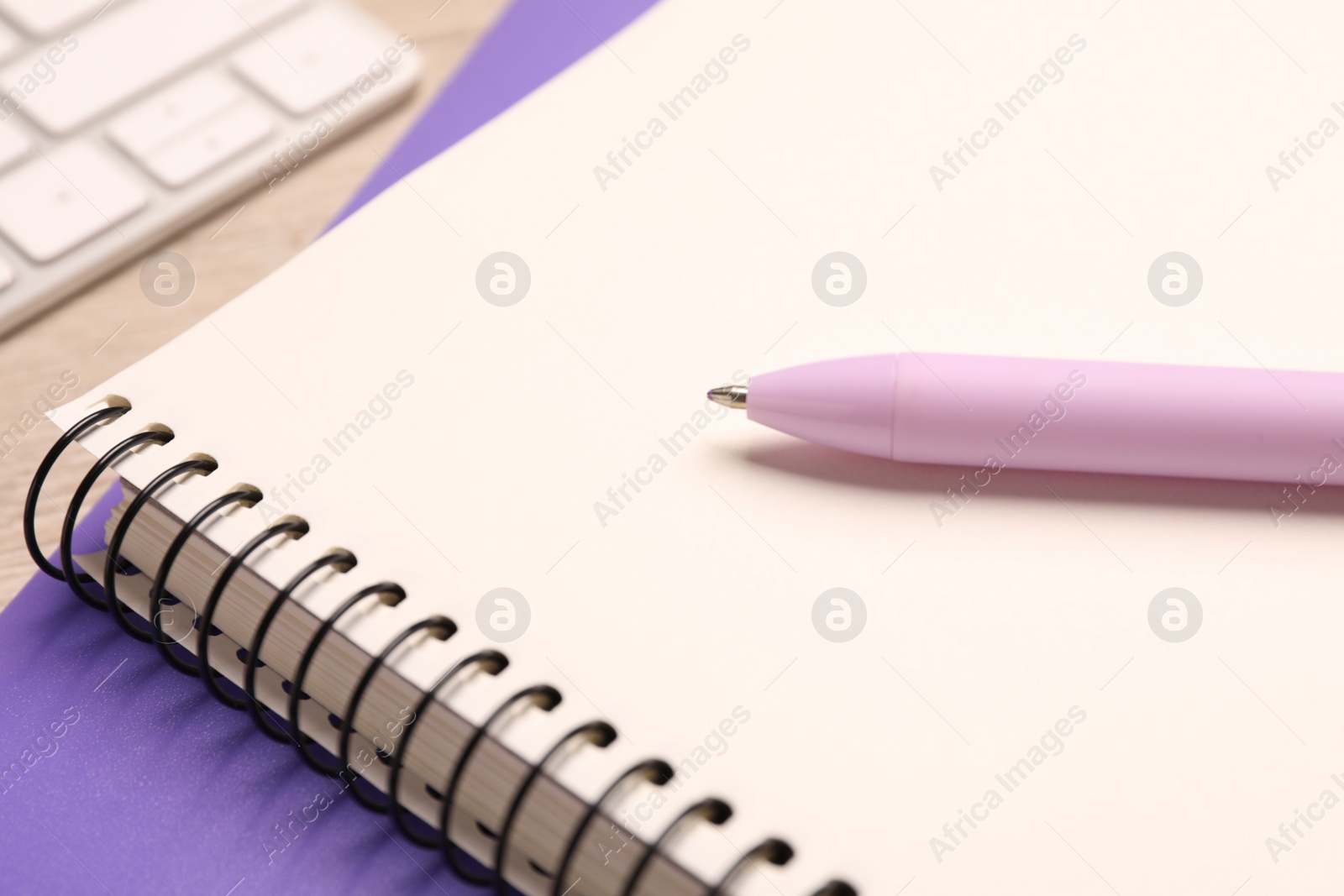 Photo of Spiral notebook and pen on table, closeup