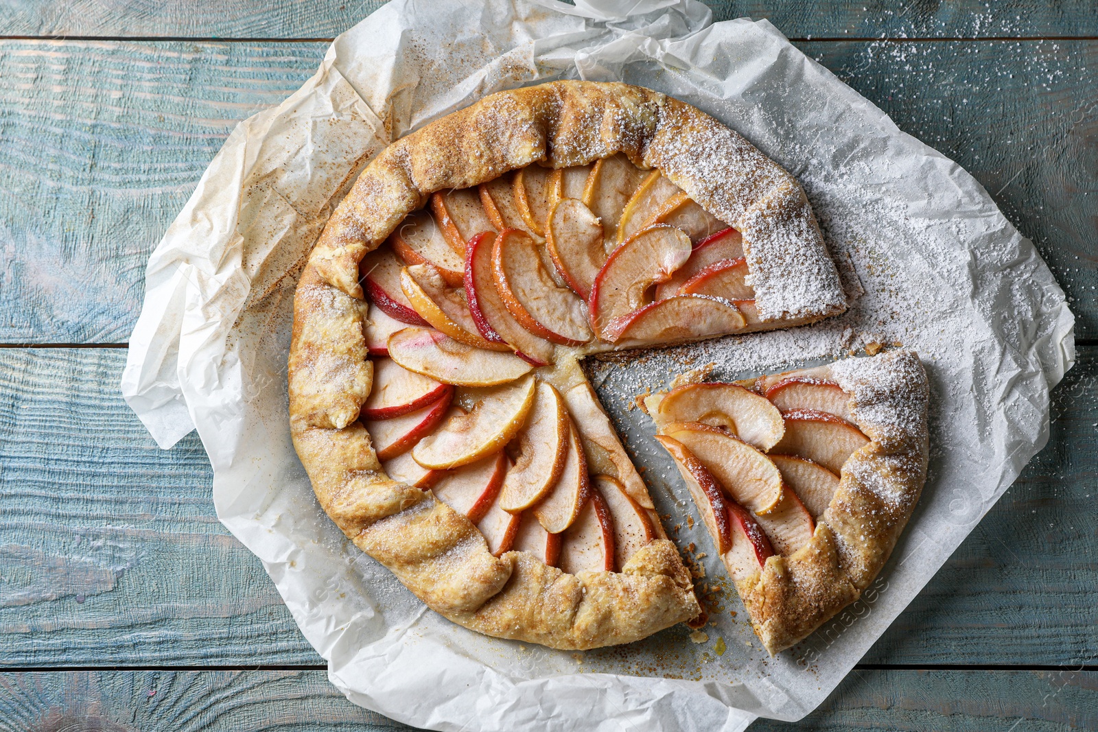 Photo of Delicious apple galette on wooden table, top view