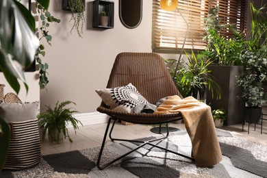 Lounge area interior with comfortable armchair and beautiful houseplants