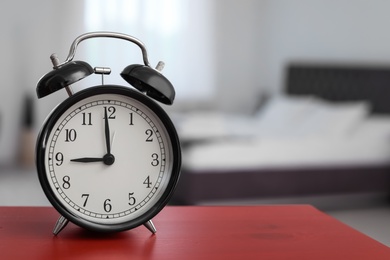 Photo of Alarm clock on table in bedroom. Time to wake up