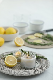 Photo of Natural homemade mosquito repellent candle and ingredients on white table