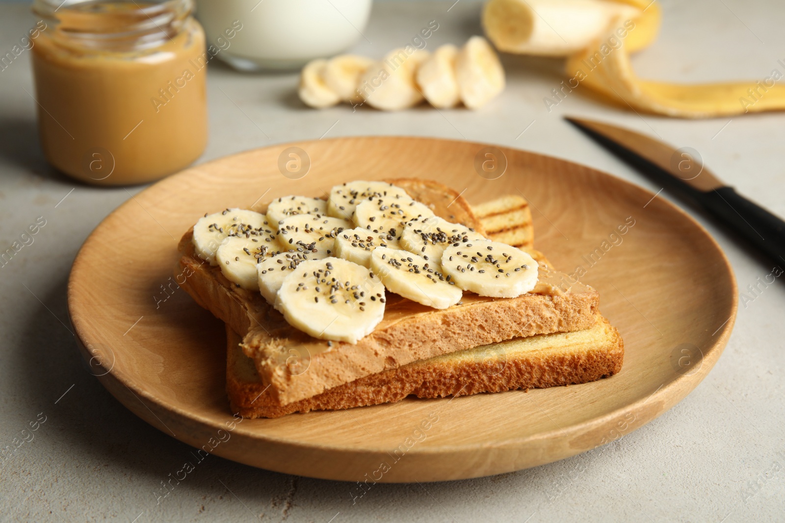 Photo of Tasty toasts with banana, peanut butter and chia seeds on plate