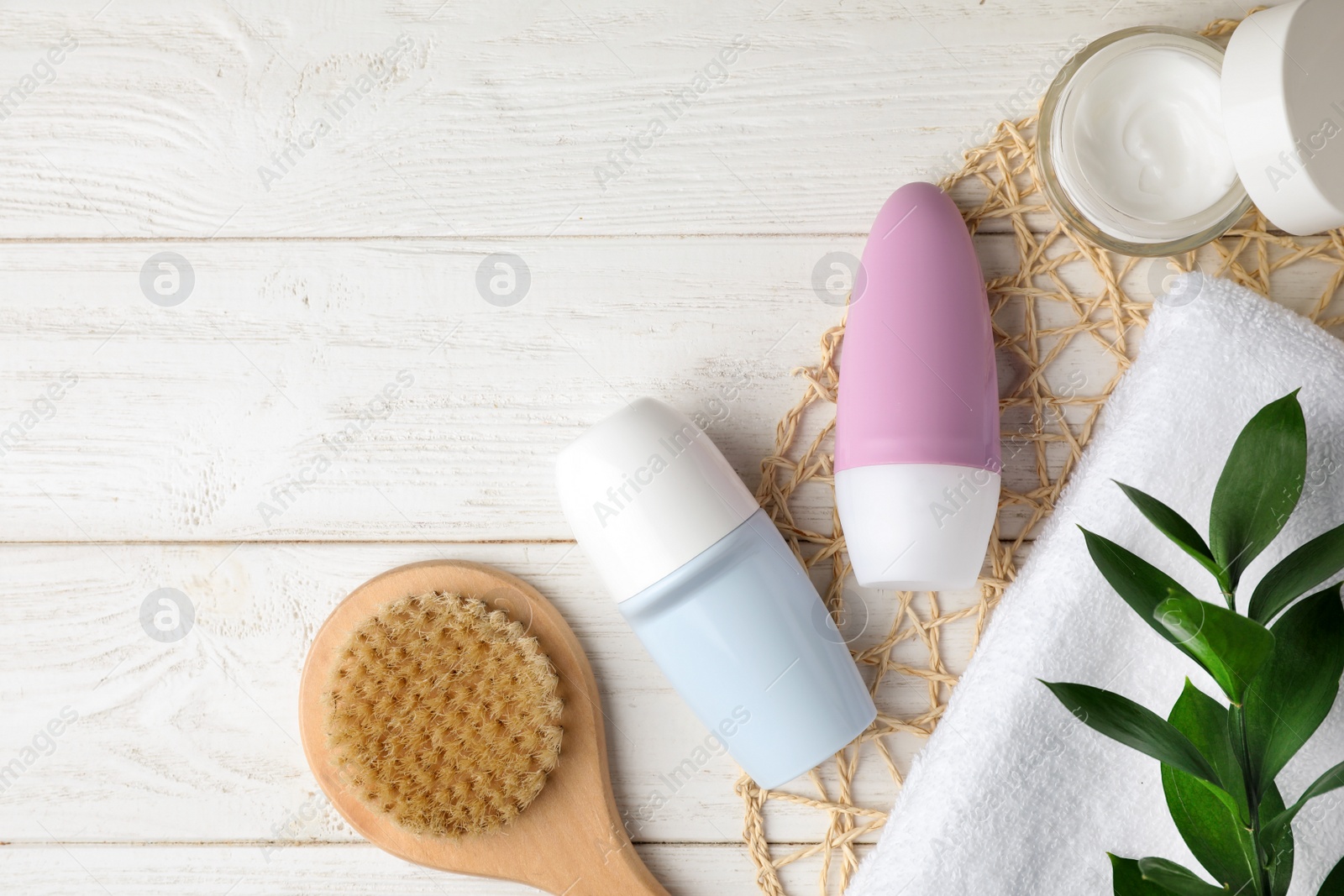 Photo of Flat lay composition with natural deodorants and bath accessories on white wooden table. Space for text