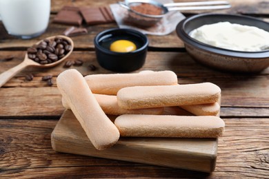 Photo of Tasty cookies and other ingredients for tiramisu on wooden table