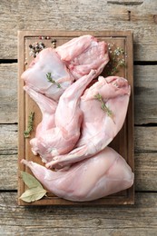 Photo of Fresh raw rabbit meat and spices on wooden table, top view