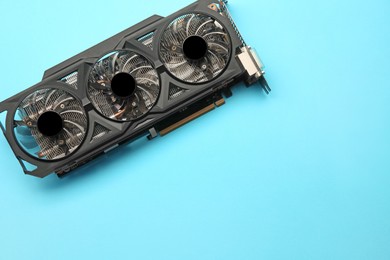 Photo of One graphics card on light blue background, top view. Space for text