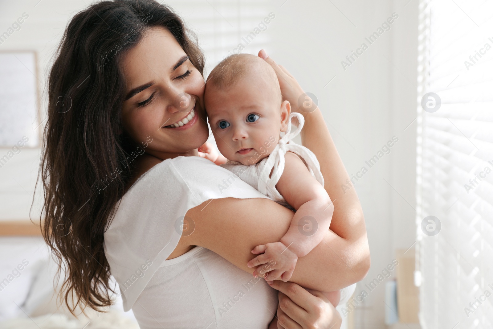 Photo of Happy young mother with her cute baby at home