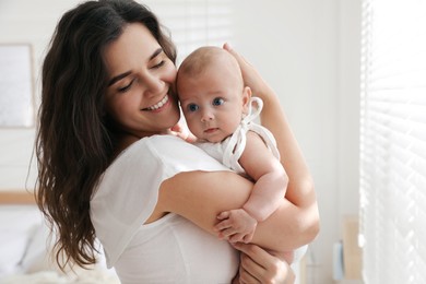 Happy young mother with her cute baby at home