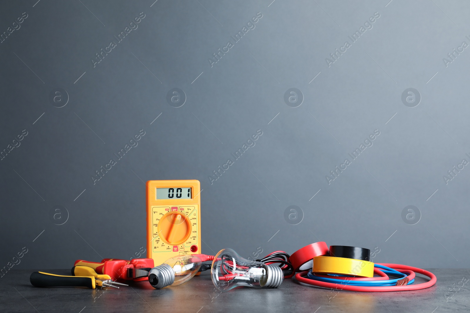 Photo of Set of electrician's tools on table against gray background. Space for text