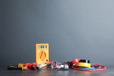 Photo of Set of electrician's tools on table against gray background. Space for text