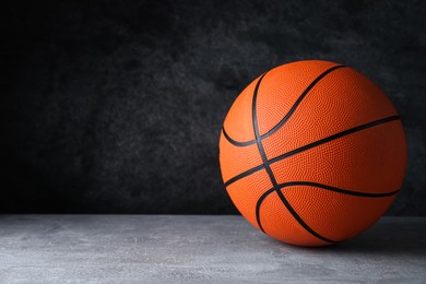 Photo of Orange ball on light grey table, space for text. Basketball equipment
