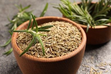 Bowl with dry and fresh rosemary on grey table, closeup