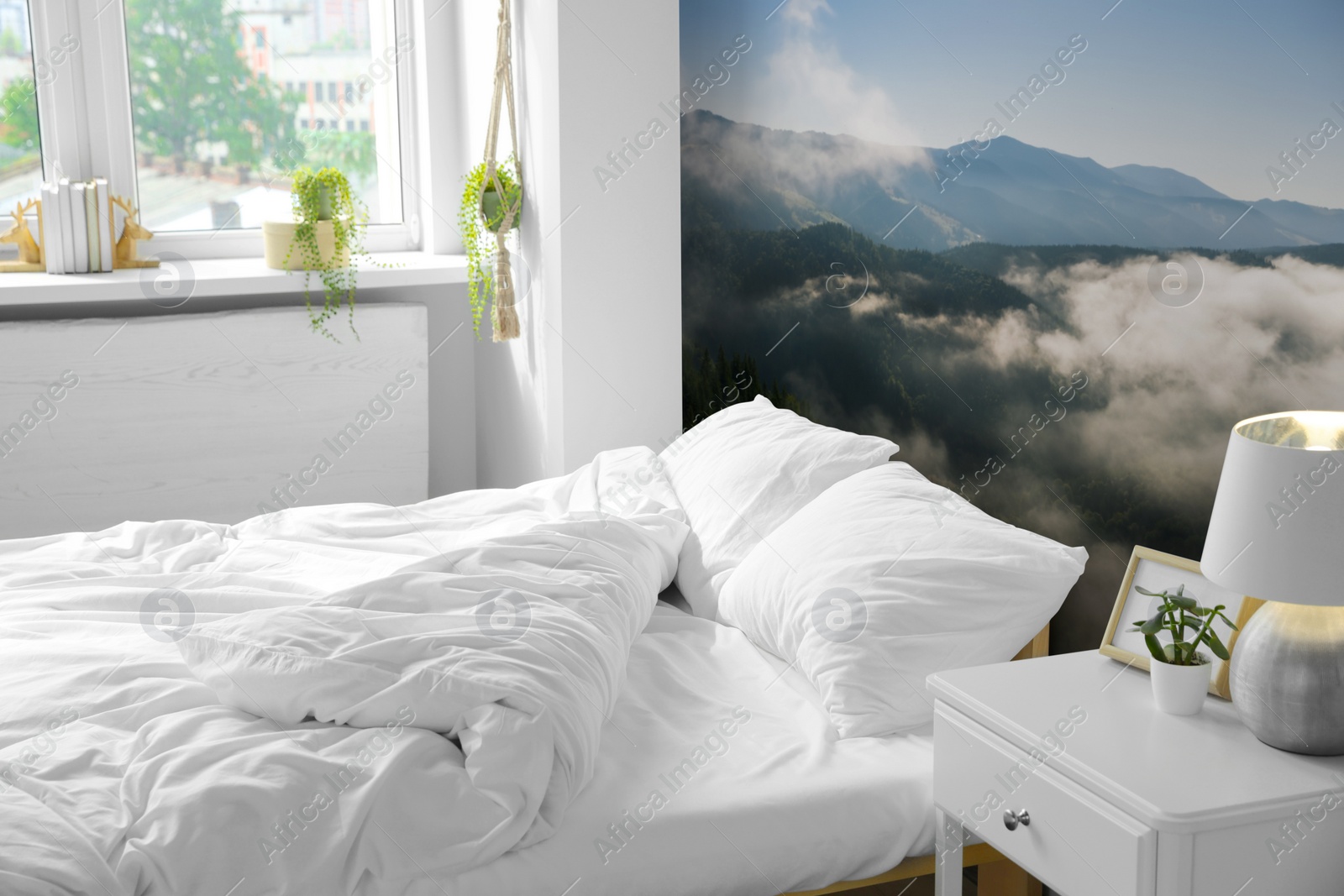 Image of Light bedroom. Interior with comfortable bed and mountain landscape wallpapers